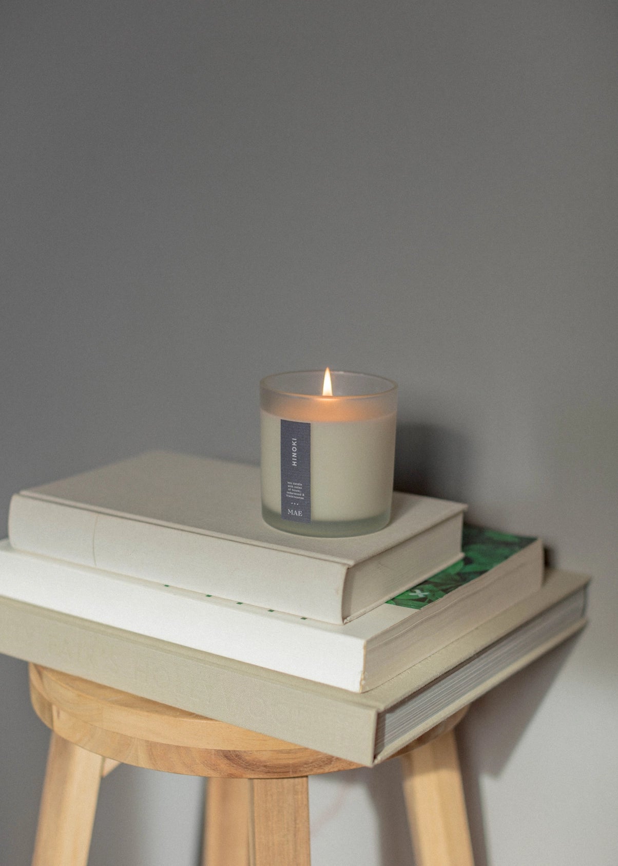 Candle on a stack of books with a gray background