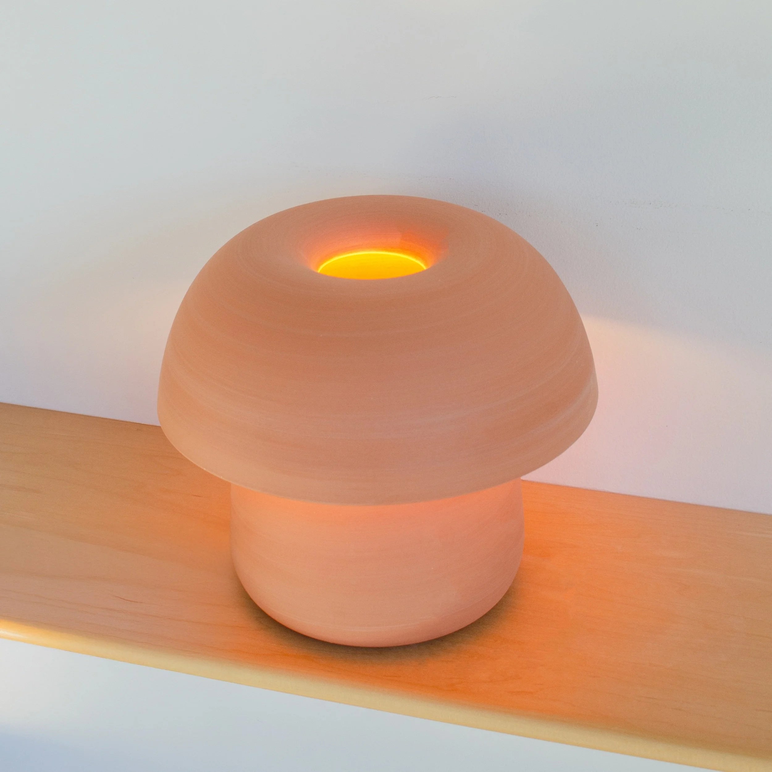 Ceramic lamp with a warm glow on a wooden surface